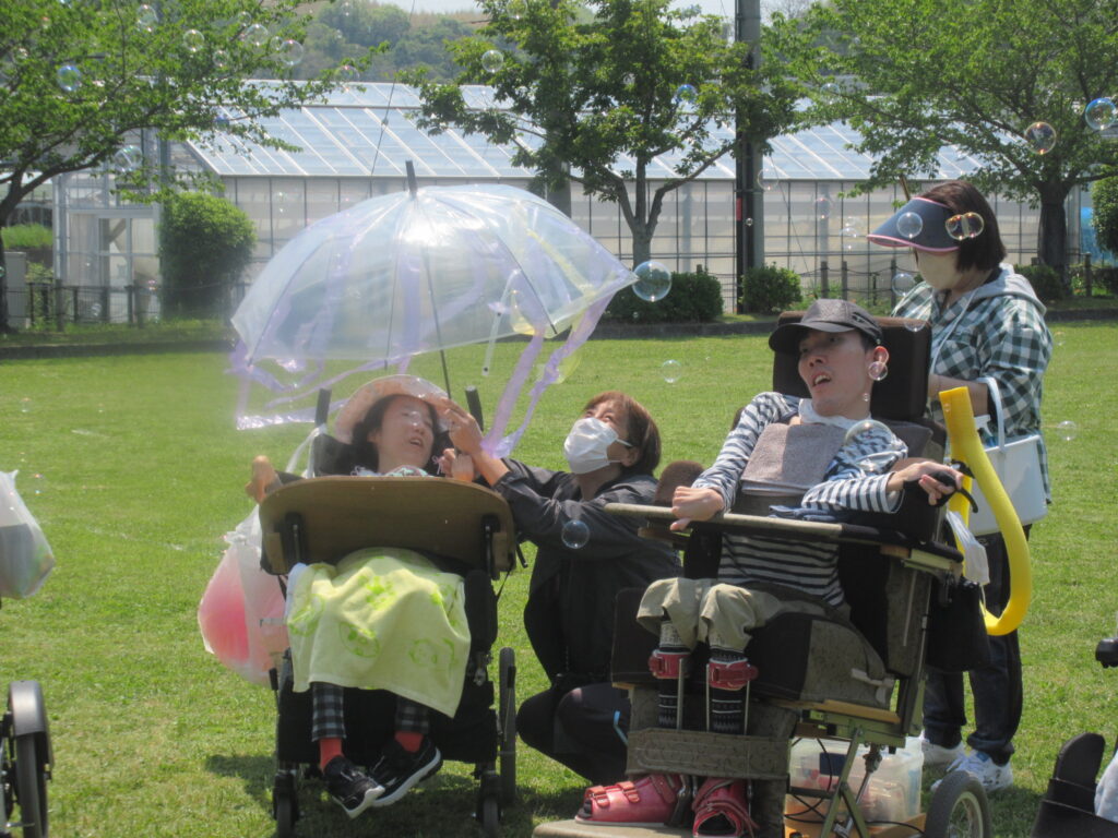 みすぎ 公園でシャボン玉と飾りのついた透明の傘で楽しむ利用者様