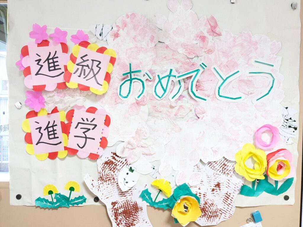 さん　進級進学おめでとうと書かれた花の飾り