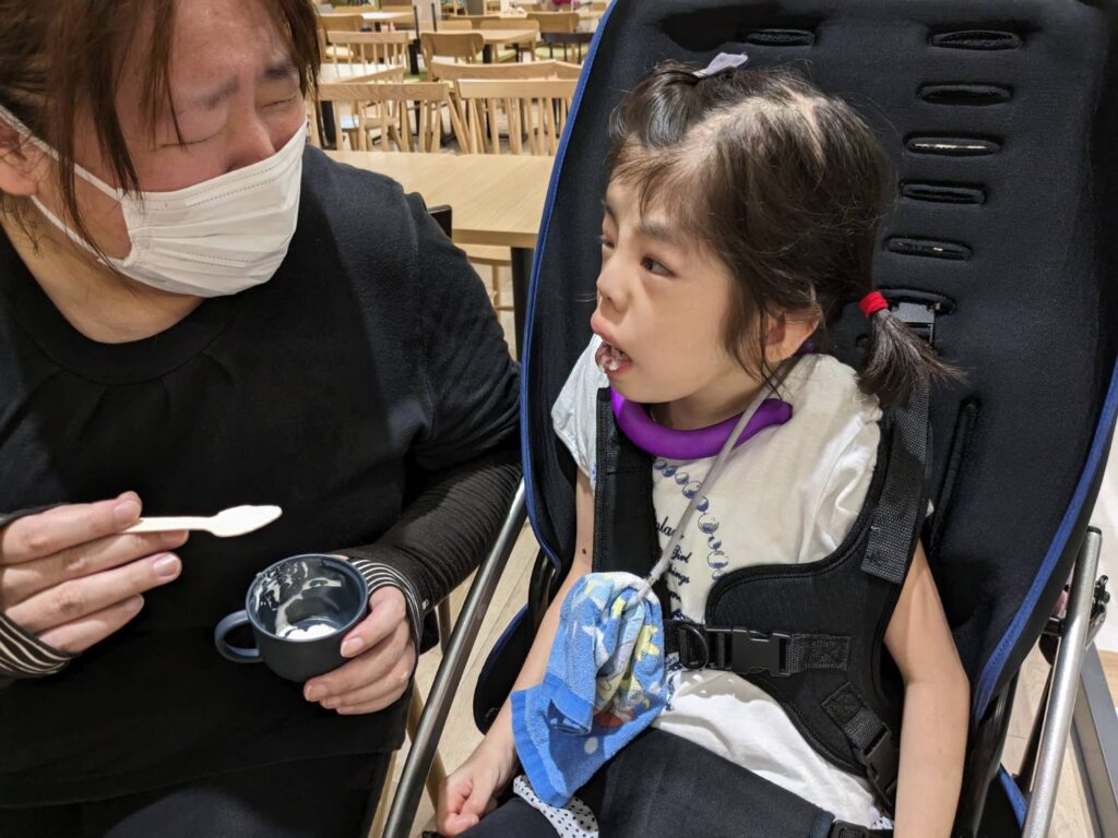 さん　支援員から飲み物を食べさせてもらっている利用者様