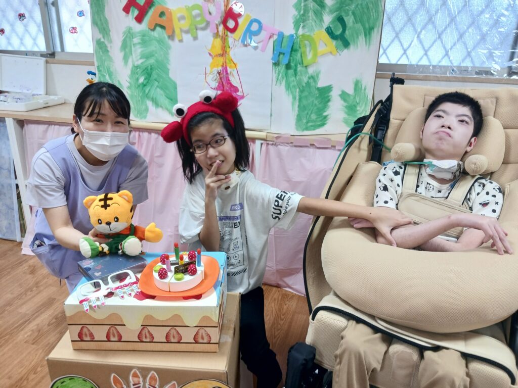 しまじろうと誕生日ケーキの前でのさんの利用者様の笑顔